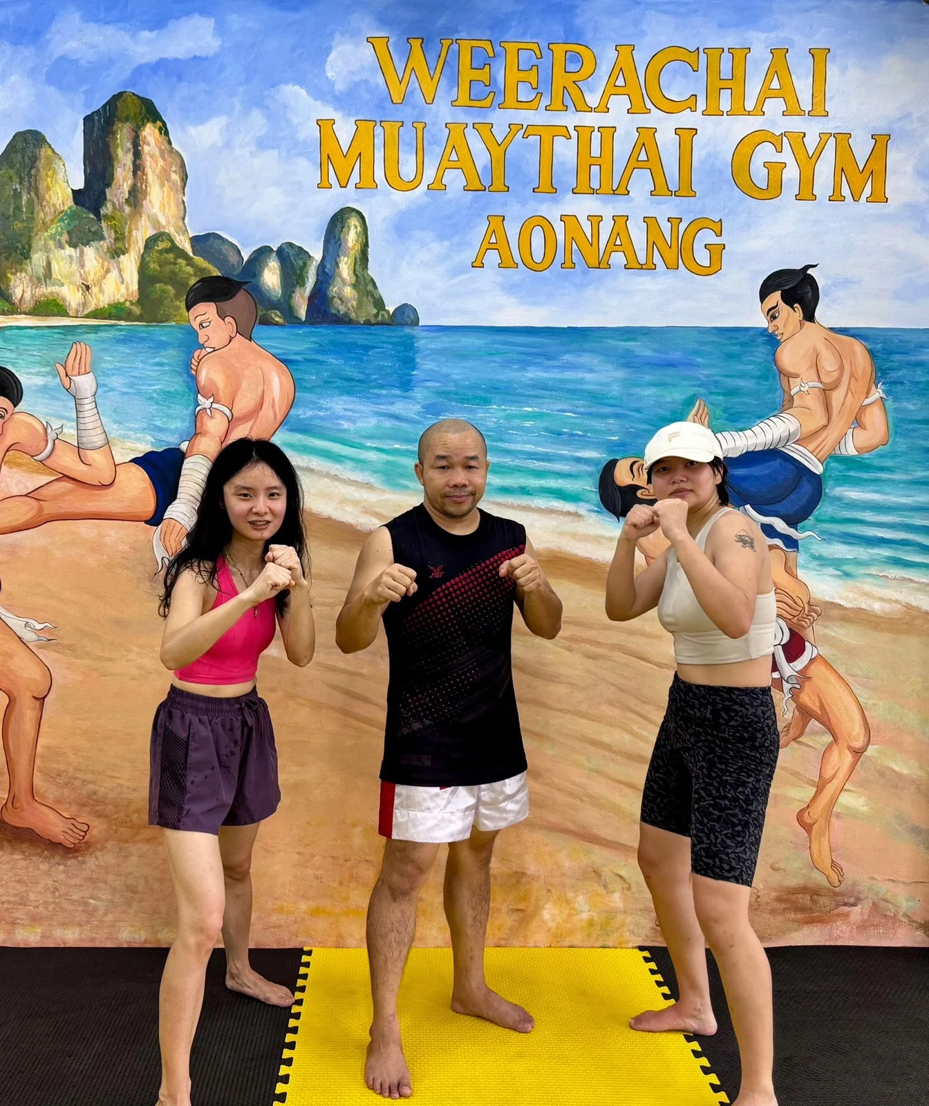 Three people posing together inside the gym