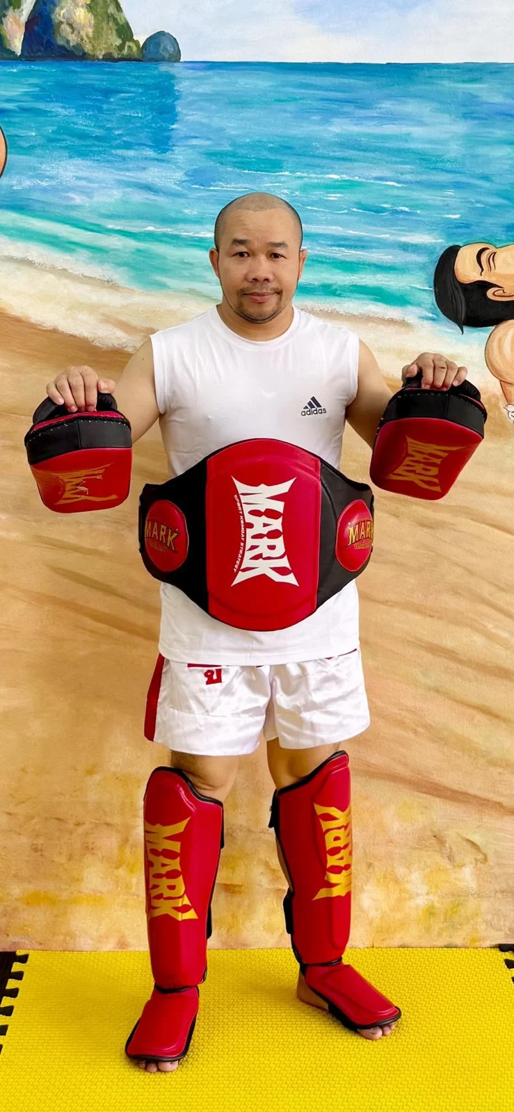 Person holding red training pads inside the gym